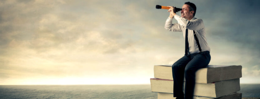 Auf dem Bild ist ein Mann zu sehen, der auf einem Stapel riesiger Bücher sitzt und durch ein Teleskop in die Ferne guckt